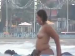 Dirty brown skin girl rides her partner in public beach